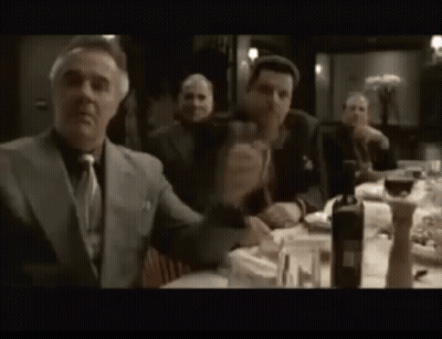 Man In Suit And Tie Sitting At Table GIF