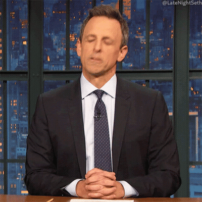 Man In Suit And Tie Sitting At Table With Hands Folded GIF