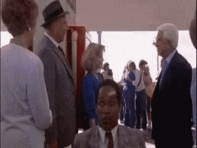 Man In Suit And Tie Sitting Before Group GIF