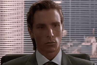 Man In Suit And Tie Sitting By Blinds GIF