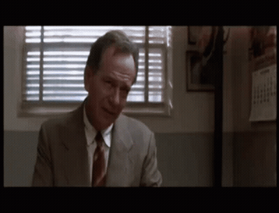 Man In Suit And Tie Sitting By Window GIF