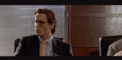 Man In Suit And Tie Sitting In Chair By Window GIF