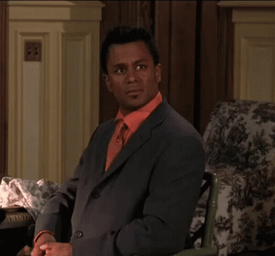 Man In Suit And Tie Sitting In Chair GIF