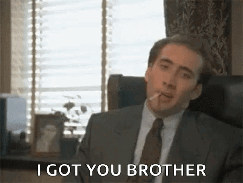 Man In Suit And Tie Sitting In Chair Smoking Cigarette GIF