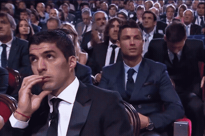 Man In Suit And Tie Sitting In Crowd GIF