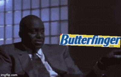 Man in Suit and Tie Sitting in Front of Butterfinger Bar