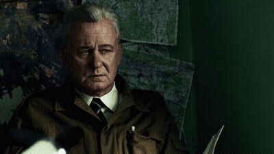 Man in Suit and Tie Sitting in Front of Map Wall