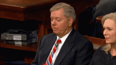 Man In Suit And Tie Sitting In Front Of Woman GIF
