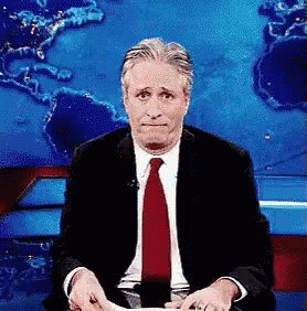 Man In Suit And Tie Sitting In Front Of World Map GIF