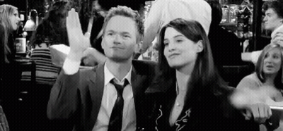 Man In Suit And Tie Sitting Next To Woman In Crowded Bar GIF