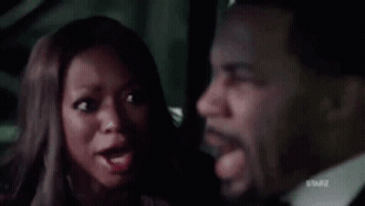 Man In Suit And Tie Sitting Next To Woman In Dark Room GIF