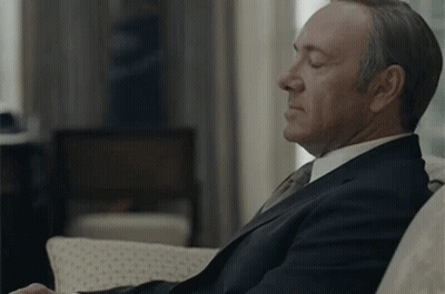 Man In Suit And Tie Sitting On Couch GIF