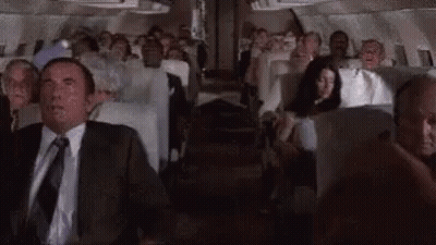 Man In Suit And Tie Sitting On Plane GIF