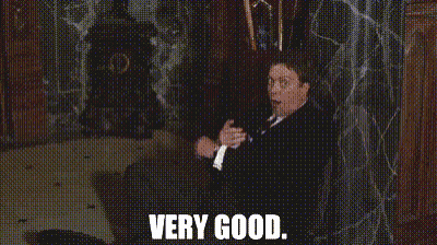 Man In Suit And Tie Sitting Saying Very Good GIF