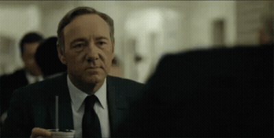 Man In Suit And Tie Sitting With Drink GIF