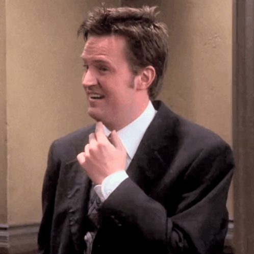Man In Suit And Tie Smiling And Fixing Tie GIF