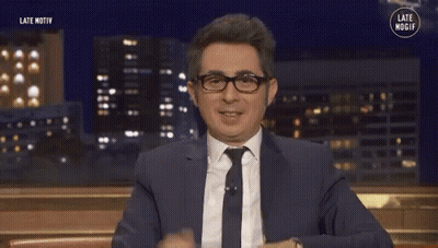 Man In Suit And Tie Smiling And Waving GIF