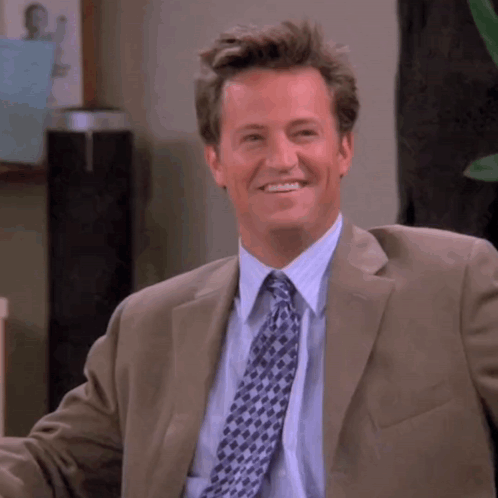 Man In Suit And Tie Smiling At Camera GIF