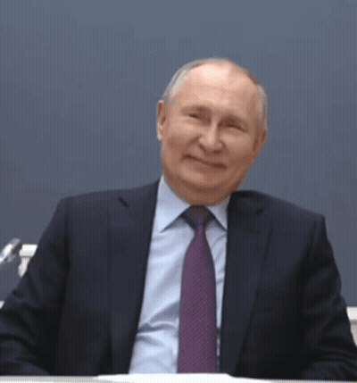 Man In Suit And Tie Smiling At Desk GIF