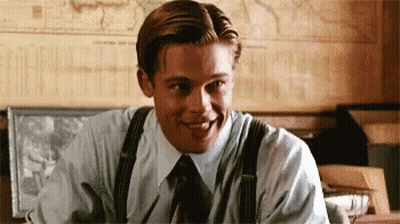 Man In Suit And Tie Smiling At Desk GIF