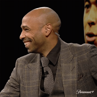 Man In Suit And Tie Smiling At Paramount Sign GIF