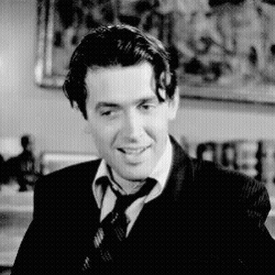 Man In Suit And Tie Smiling In Black And White GIF