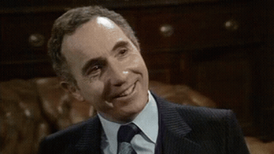 Man In Suit And Tie Smiling In Chair GIF