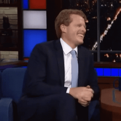 Man In Suit And Tie Smiling In Chair GIF