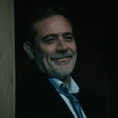 Man In Suit And Tie Smiling In Dark GIF