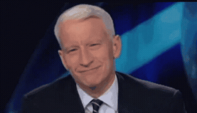 Man In Suit And Tie Smiling In Front Of Blue Background GIF