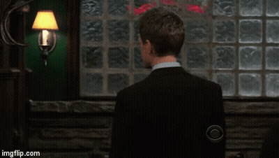 Man In Suit And Tie Smiling In Front Of Brick Wall GIF