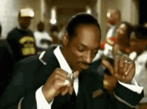 Man In Suit And Tie Smoking In Crowded Room GIF