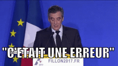 Man In Suit And Tie Speaking At Podium With Flag GIF