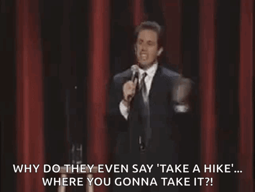 Man In Suit And Tie Standing At Microphone On Stage GIF