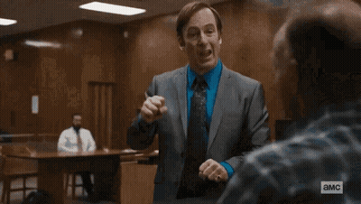 Man In Suit And Tie Standing Before American Flag GIF