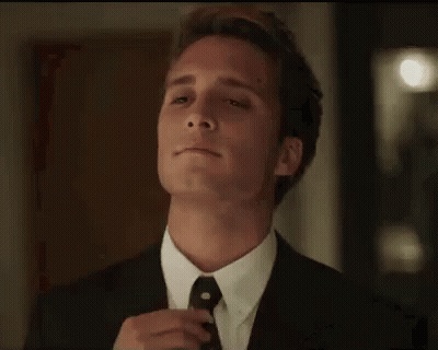 Man In Suit And Tie Standing Before Door Eyes Closed GIF