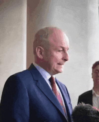 Man In Suit And Tie Standing Before Group GIF