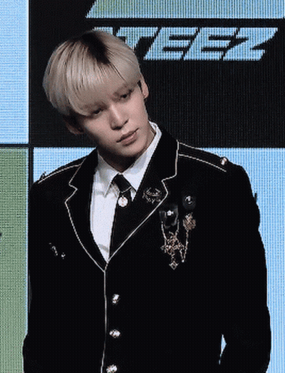 Man In Suit And Tie Standing Before Screen Saying Tbz GIF