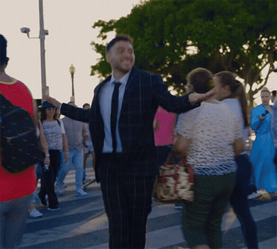 Man In Suit And Tie Standing In Crowd GIF