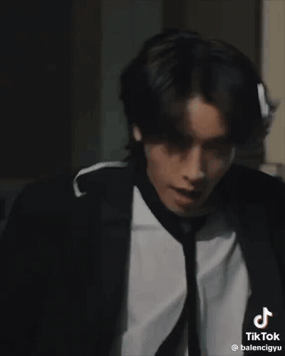 Man In Suit And Tie Standing In Dark Room GIF