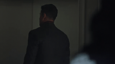 Man In Suit And Tie Standing In Dark GIF