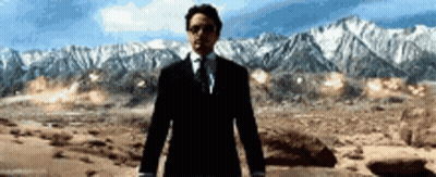 Man In Suit And Tie Standing In Desert With Mountains GIF
