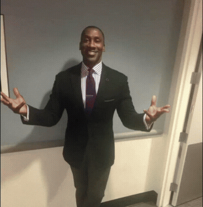 Man In Suit And Tie Standing In Doorway With Arms Outstretched GIF