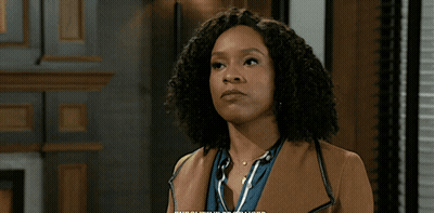 Man In Suit And Tie Standing In Front Of Bookshelf GIF