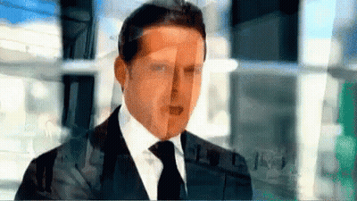 Man In Suit And Tie Standing In Front Of Building GIF