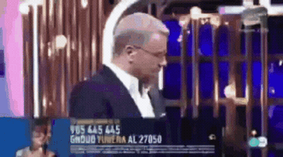 Man In Suit And Tie Standing In Front Of Cage On TV Screen GIF