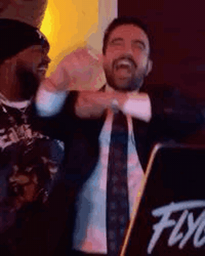 Man In Suit And Tie Standing In Front Of DJ Booth GIF