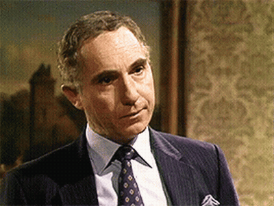 Man In Suit And Tie Standing In Front Of Framed Picture GIF
