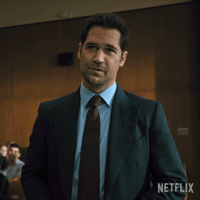 Man In Suit And Tie Standing In Front Of Netflix Sign GIF