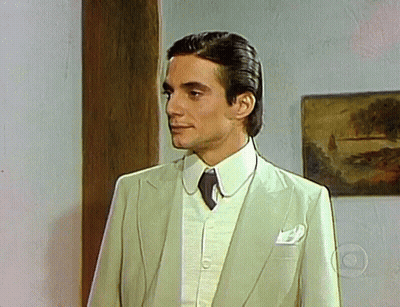 Man In Suit And Tie Standing In Front Of Picture GIF
